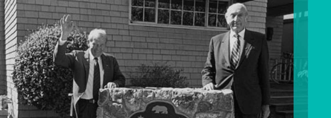 Bill Hewlett (left) and Dave Packard standing in front of the Hewlett Packard Garage US National Register of Historic Places sign.